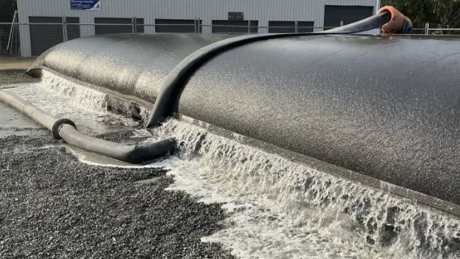 Dewatering system processing dredged material at an industrial site